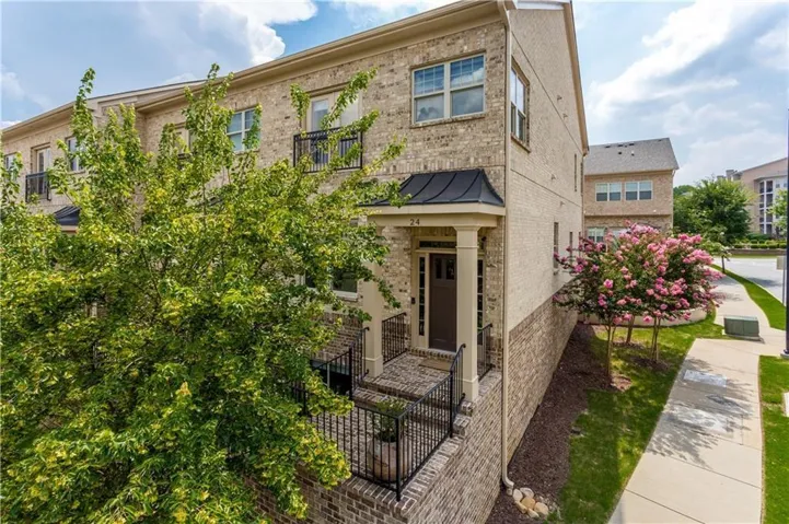 Brick exterior with black iron railings and a covered entry