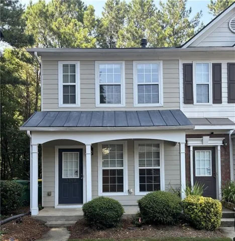 Two-story facade with light beige siding and white trim