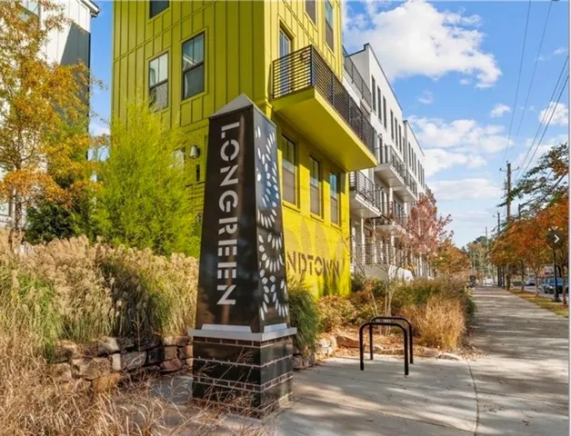 Modern multi-story building featuring vibrant yellow siding and black-framed windows
