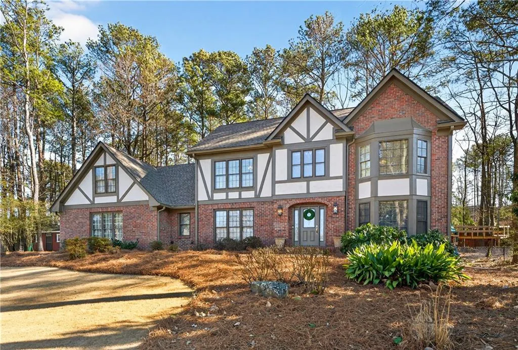 Tudor home featuring stucco siding and brick siding.
