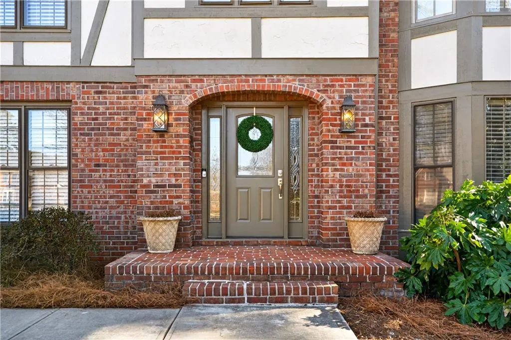Entrance to property featuring brick siding