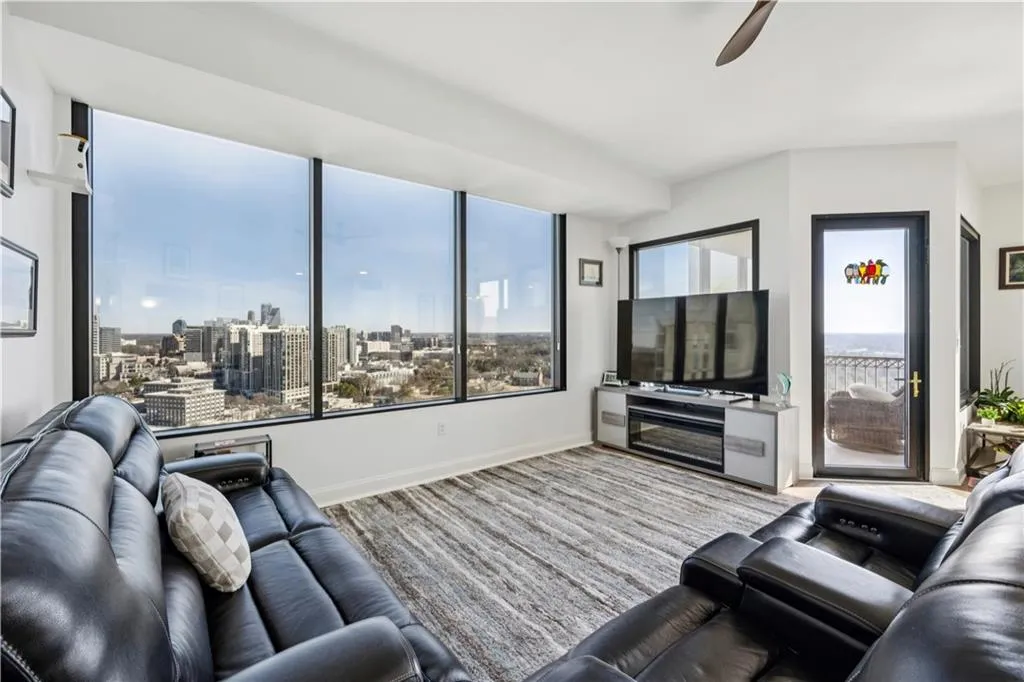 Living area with ceiling fan and baseboards