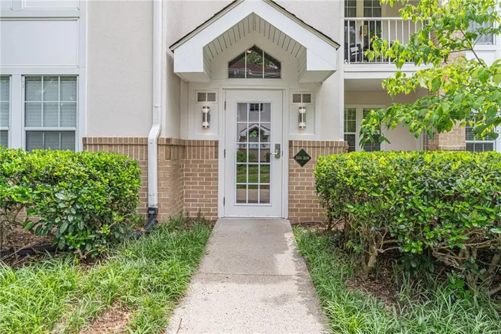 Welcoming entry with a white paneled door, decorative transom, and dual wall sconces
