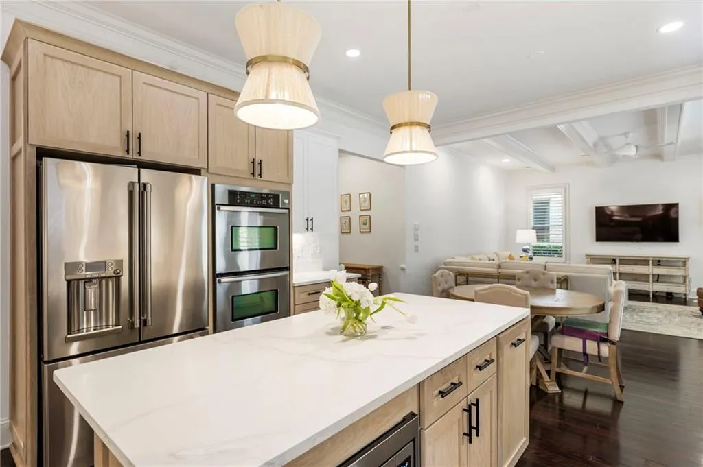 Kitchen with light brown cabinets, appliances with stainless steel finishes, open floor plan, dark wood-type flooring, and a kitchen island