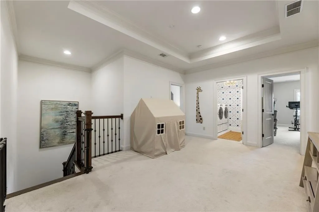 Spare room featuring light colored carpet, crown molding, a raised ceiling, and recessed lighting