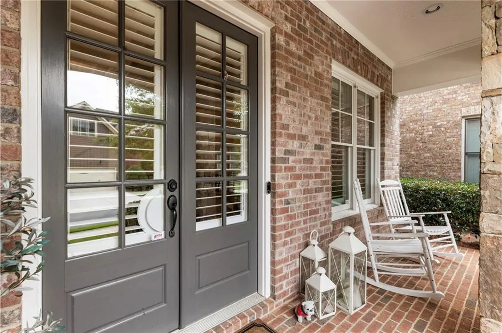 Property entrance featuring a porch and brick siding