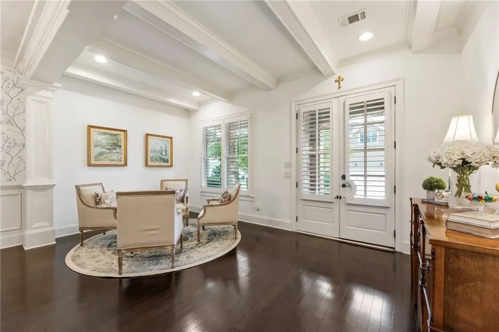 Dining room with ornate columns, dark wood finished floors, ornamental molding, beam ceiling, and recessed lighting