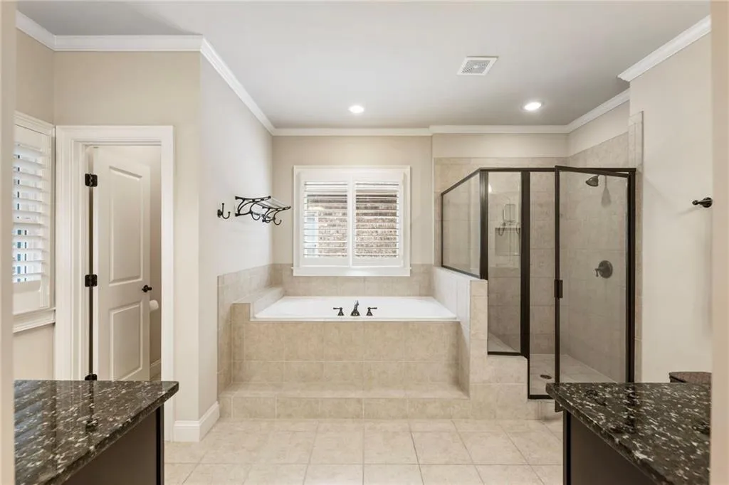 Bathroom with vanity, light tile patterned flooring, a garden tub, a stall shower, and ornamental molding