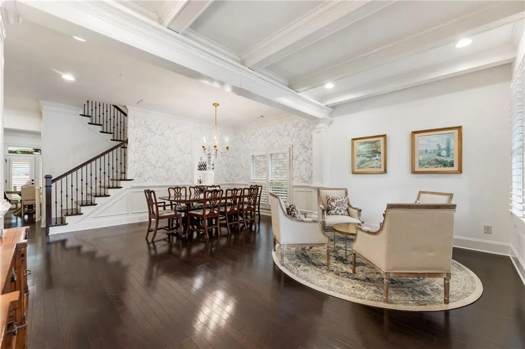 Dining space featuring dark wood-type flooring, stairs, a chandelier, recessed lighting, and beam ceiling