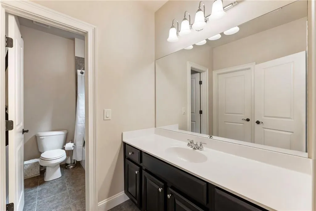 Bathroom with vanity, curtained shower, and dark tile patterned floors