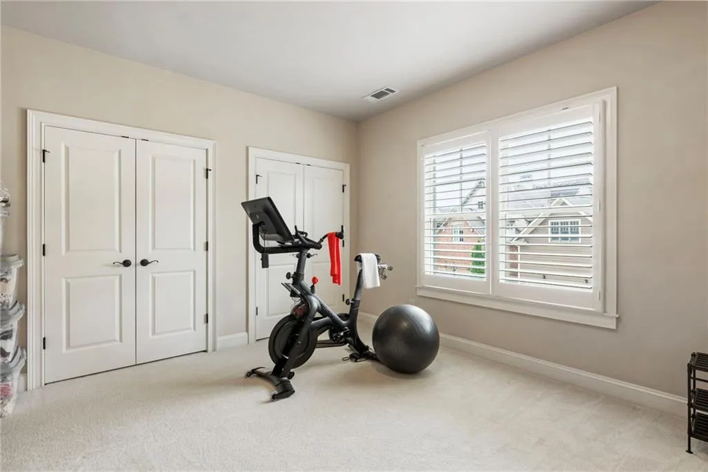 Bedroom or Exercise room featuring light carpet and baseboards