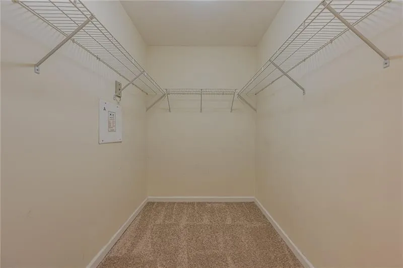 Walk in closet featuring light carpet