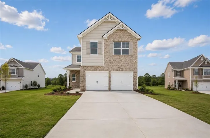 Two-story residence featuring a brick and siding exterior, a two-car garage with white doors, and a concrete driveway