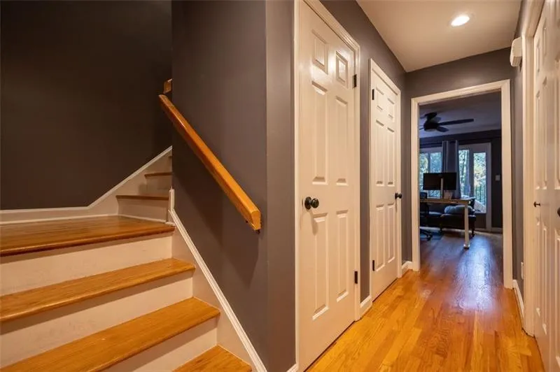 Stairway with ceiling fan and wood-type flooring