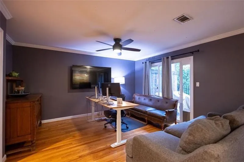 Living room with ceiling fan, wood-type flooring, and ornamental molding