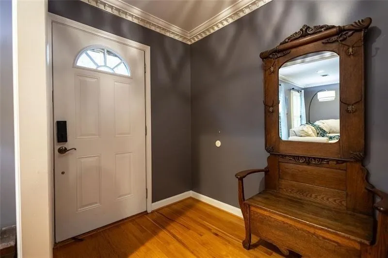 Entrance foyer with wood-type flooring, ornamental molding, and a healthy amount of sunlight