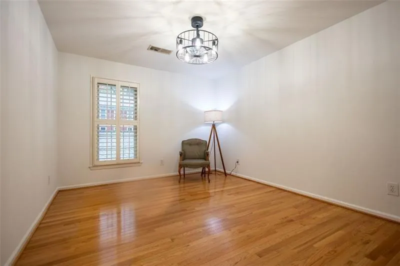 Empty room featuring a chandelier and wood-type flooring