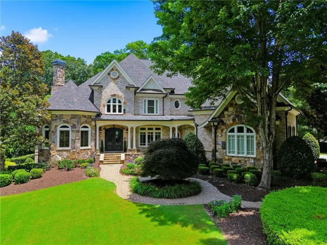Stone and stucco exterior featuring multiple gables and dormers