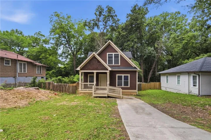 Craftsman-style home featuring shingle and horizontal siding, a covered front porch, and a concrete driveway