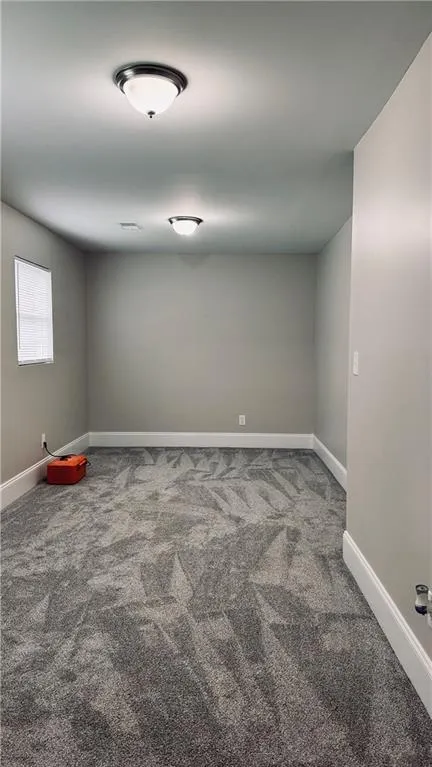 Empty room with carpet and baseboards