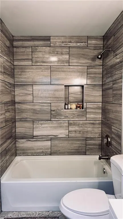 Full bath featuring toilet and  shower combination