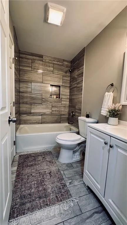 Full bath featuring vanity, shower / washtub combination, and wood tiled floors