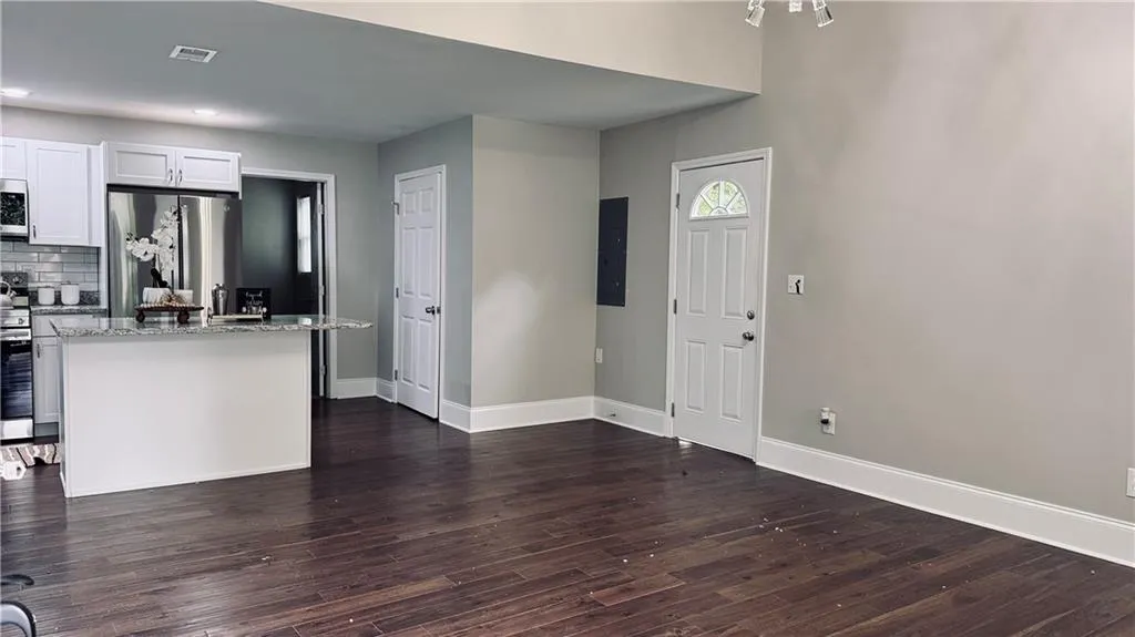 Entrance foyer with dark wood finished floors and recessed lighting