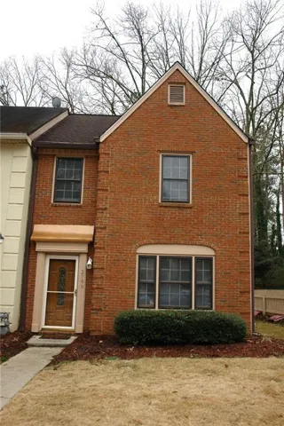 Brick facade with a prominent gabled roofline and attic vent