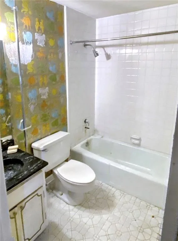 Full bath with  shower combination, vanity, and light tile patterned flooring