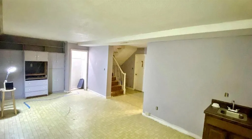 Unfurnished living room with stairway and tile patterned floors