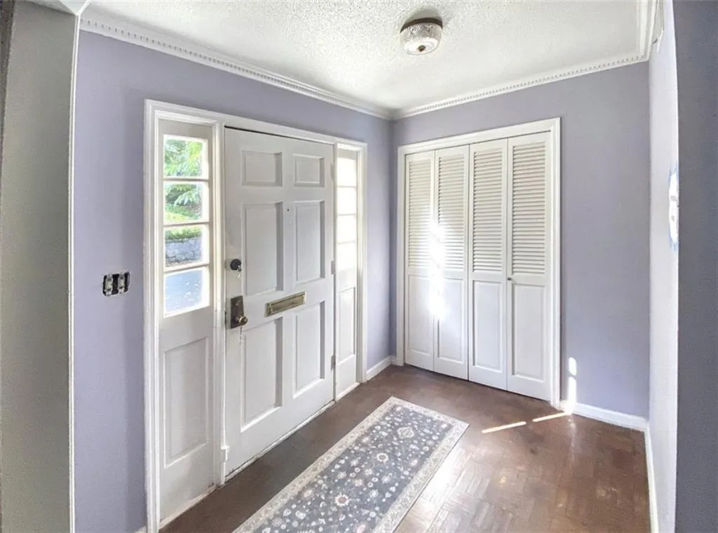 Entryway with a textured ceiling and ornamental molding