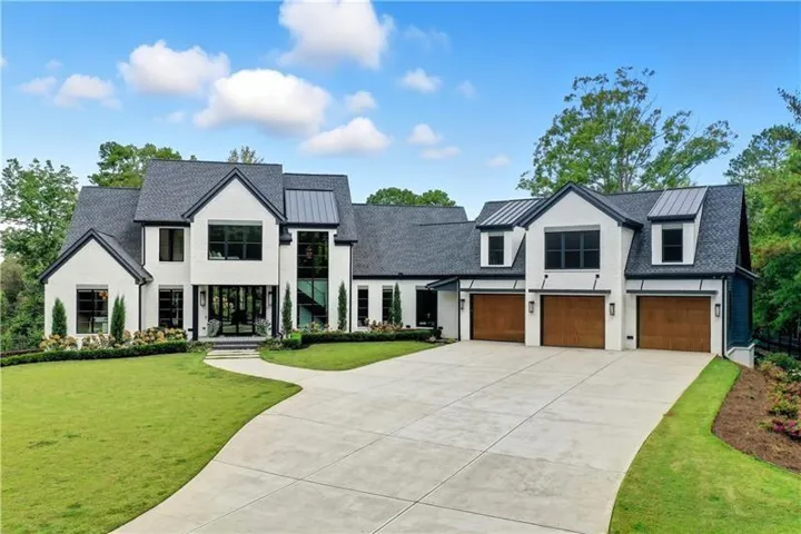 Modern transitional residence featuring a contrasting white brick and dark trim exterior