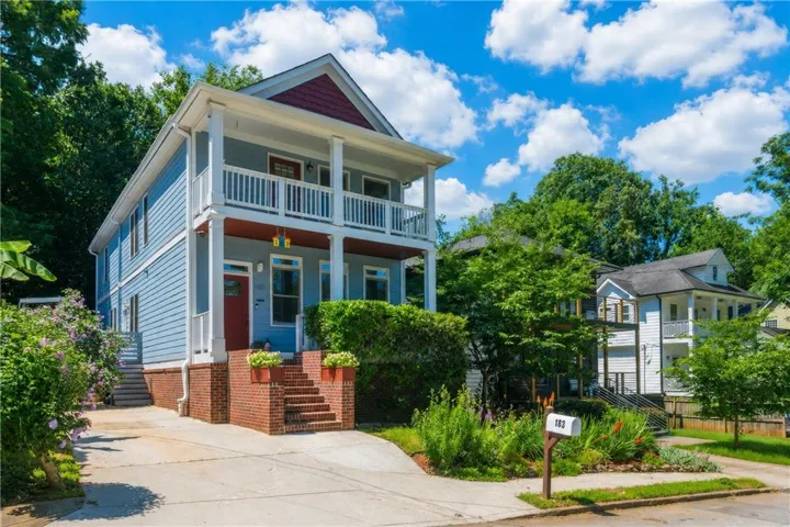 Two-story residence featuring blue siding, white trim, and a red front door