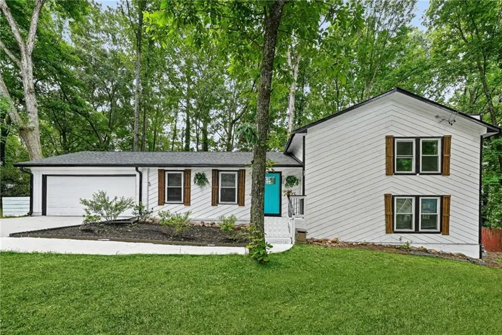 White siding exterior with a bright turquoise entry door