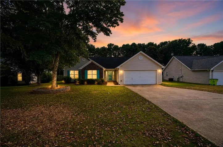 Single-story residence featuring a two-car garage, brick façade accents, and prominent teal window shutters