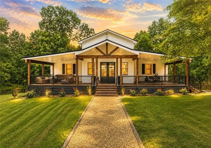Modern farmhouse exterior featuring white siding and dark trim accents