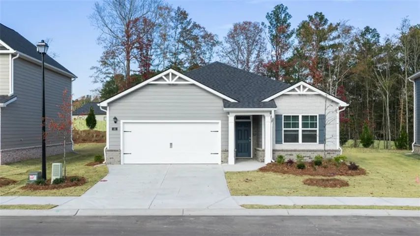 View of front of property with a front lawn, a garage, brick siding, and driveway