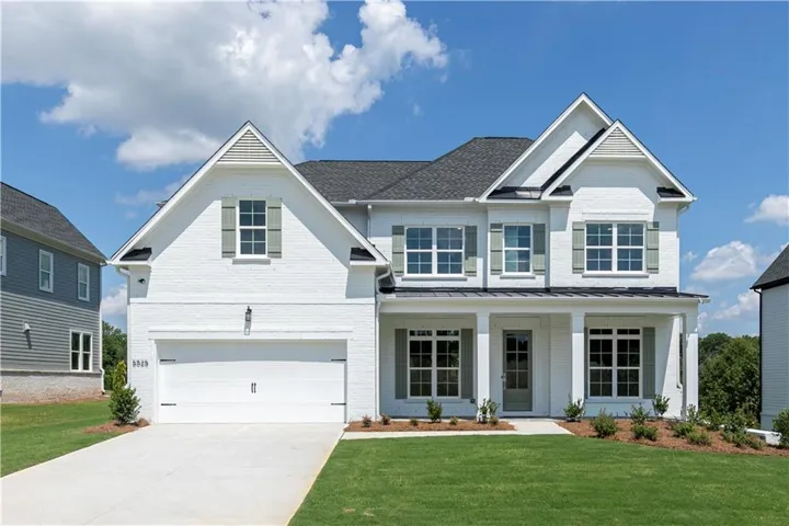 Two-story residence featuring a white brick exterior, dark asphalt shingle roof, and a covered front entry with columns