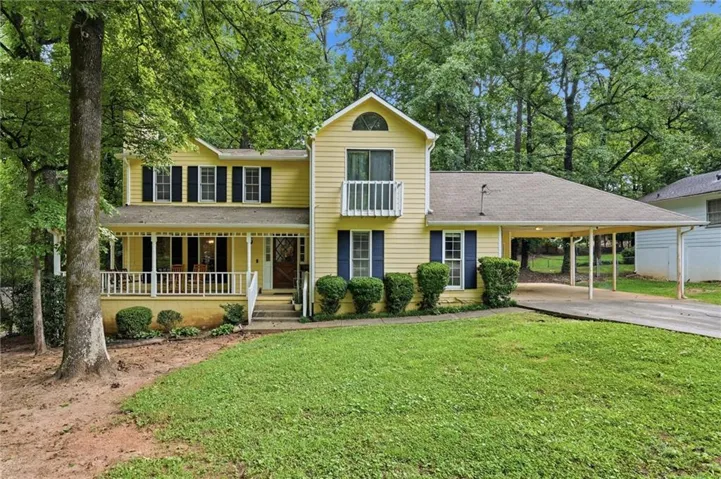 Yellow siding exterior with a welcoming front porch featuring white railings