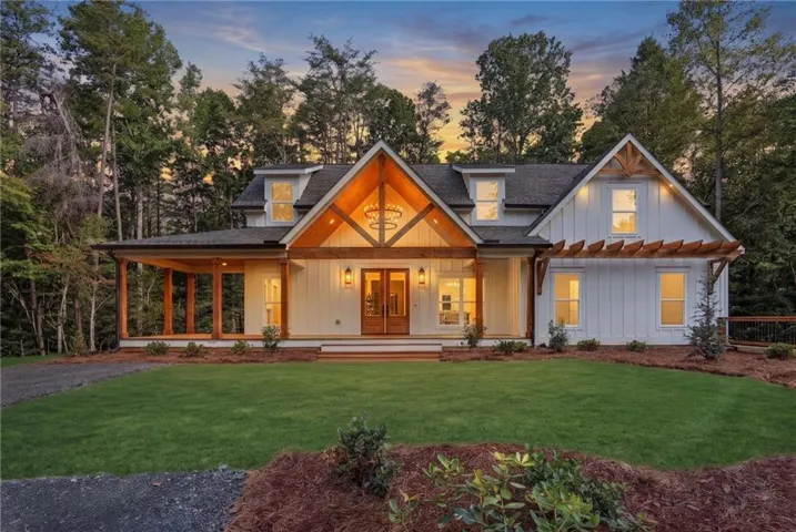 Craftsman-style exterior with board and batten siding, substantial exposed wood beams, dormer windows, and a covered porch