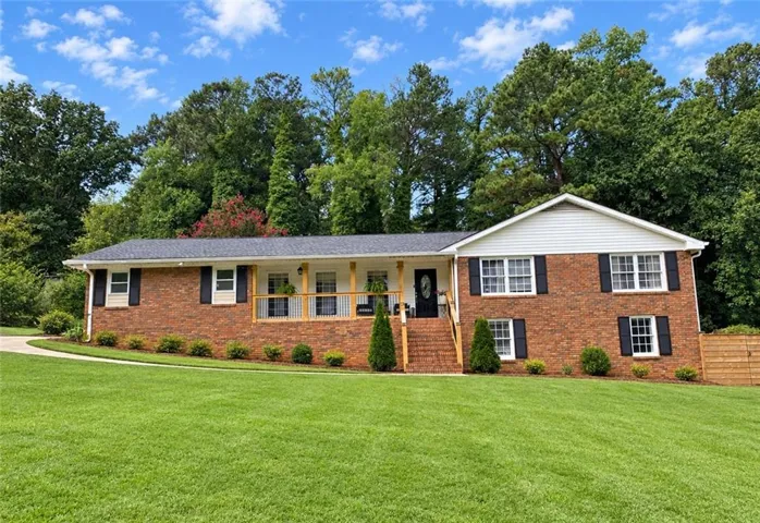 Brick exterior with white siding accents and a covered front porch featuring wood posts