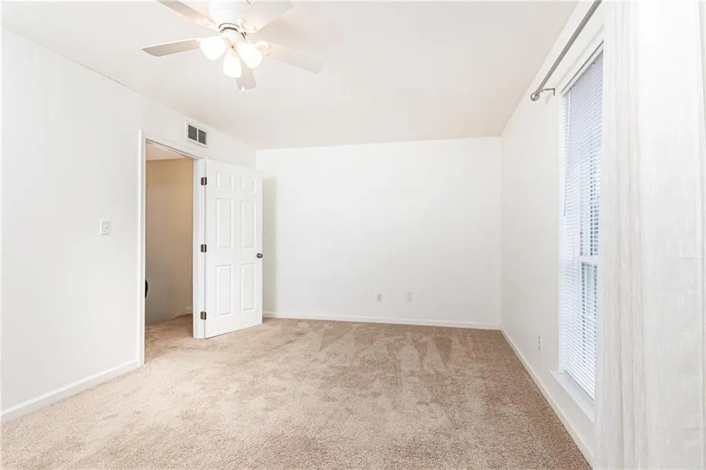 Spacious rear bedroom with ceiling fan.