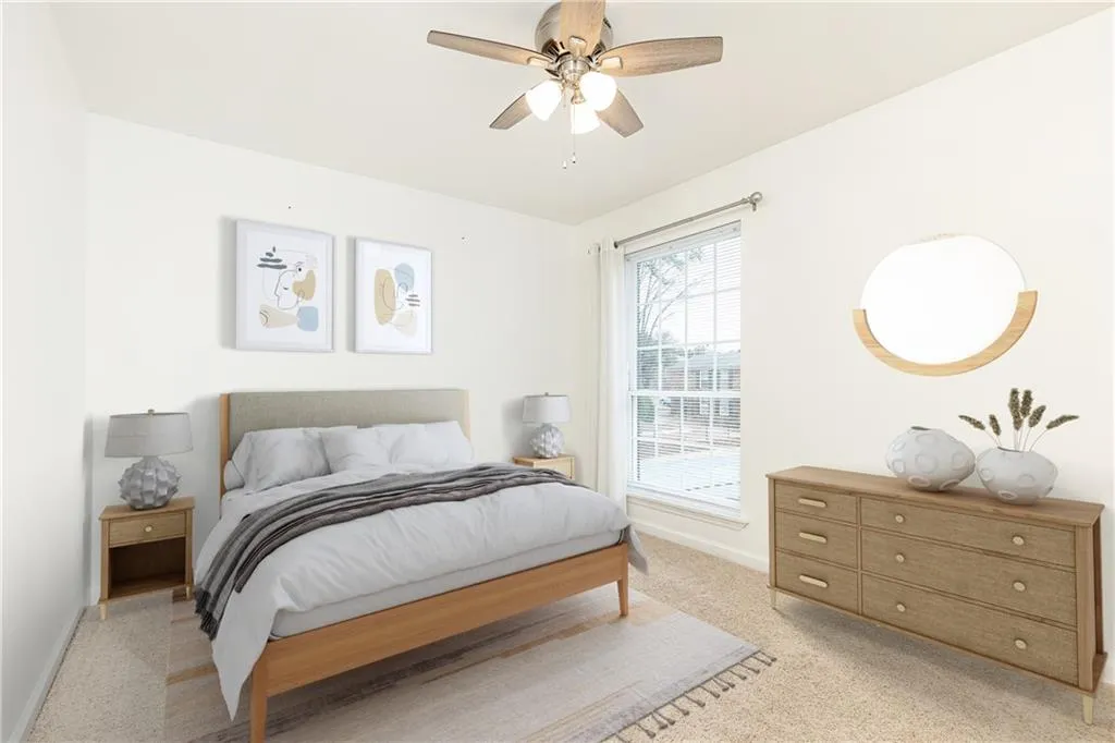 Spacious front bedroom with ceiling fan. Photo is virtually staged.