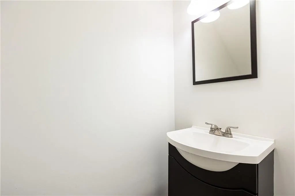 Half bathroom remodeled in 2023 is spacious and located under the stairs.