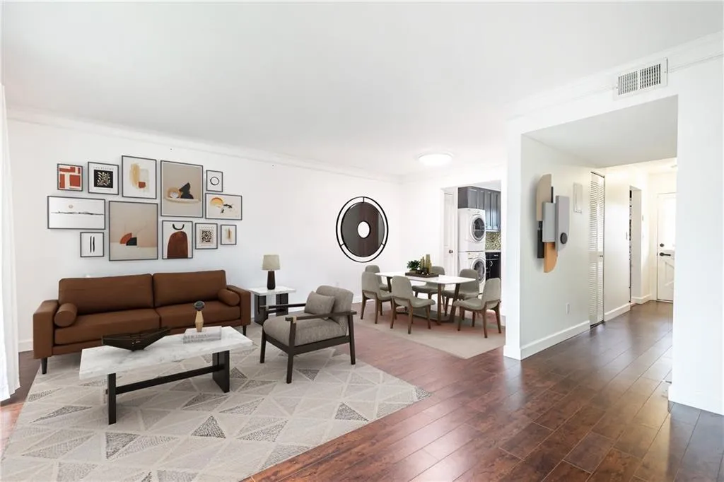 Open-concept dining room and living room. Photo has been virtually staged.