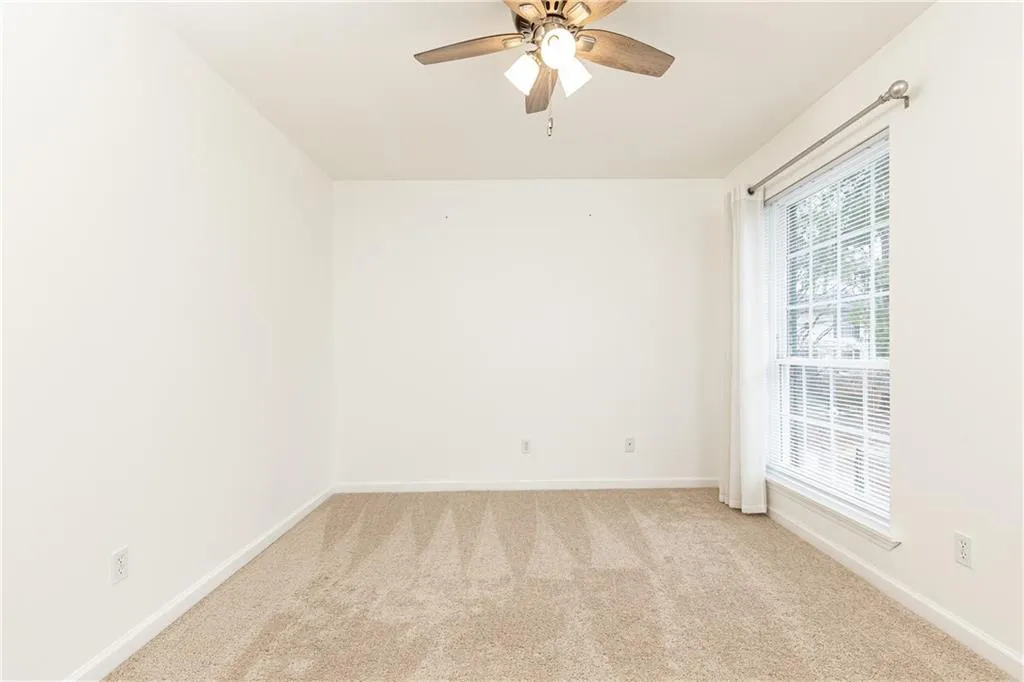 Spacious front bedroom with ceiling fan.