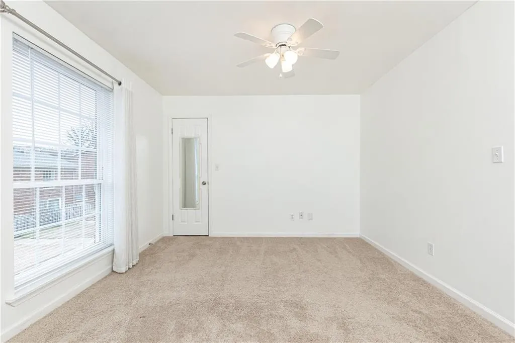 Spacious rear bedroom with ceiling fan.