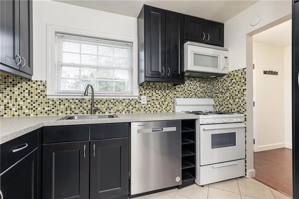 Kitchen features ample counterspace and cabinets with pantry. Gas range.