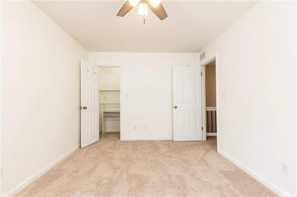 Spacious front bedroom with ceiling fan and large closet.