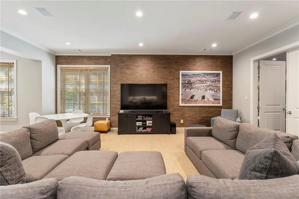 A media room with game space to the left and workout room to the right.